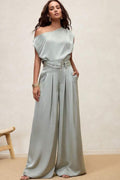 Set monocromático satinado con blusa off-shoulder y pantalón palazzo con pinzas